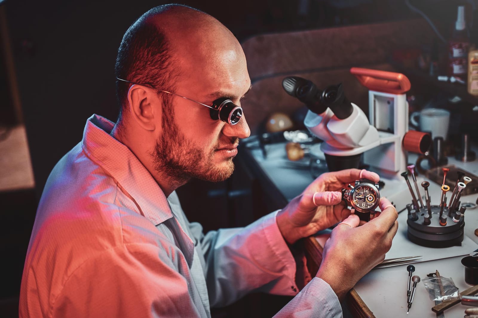 Un tecnico osserva da vicino un orologio durante la sostituzione del movimento